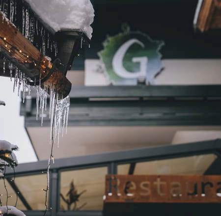 Eiszapfen hängen von einem Dach über einem Restaurant.