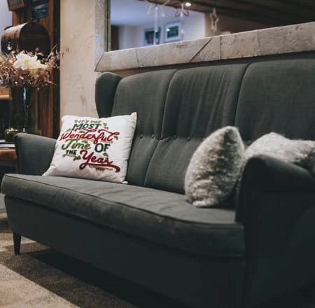 Grau Sofas mit Kissen und Deko im Hintergrund.