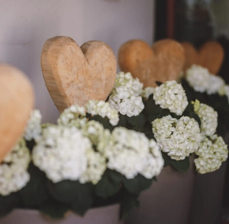 Holzherzen mit weißen Blumen in einer dekorativen Anordnung