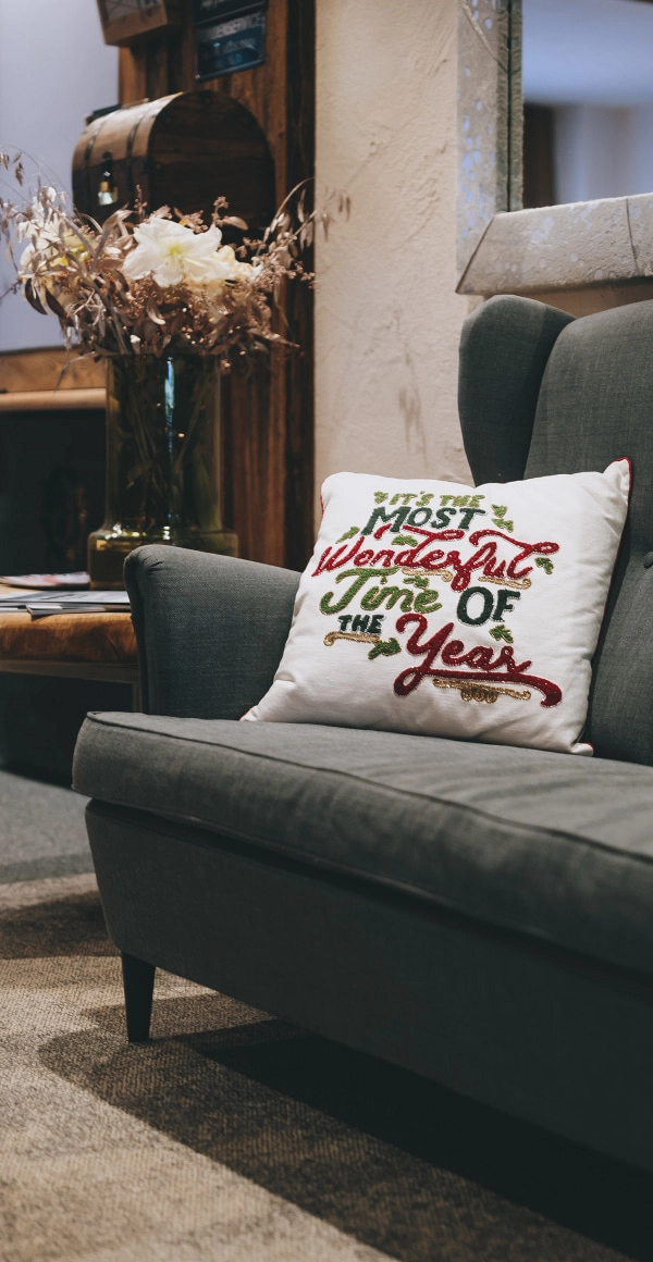 Detailfoto eines grünem Sofas mit Kissen und Dekoration.