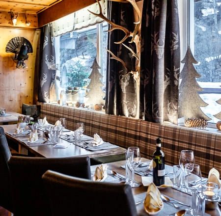 Gemütliches Restaurant mit Tischdekoration und Fenstern.