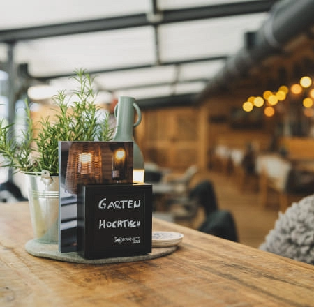 Tisch mit Pflanze, Menü und gemütlichem Restaurant-Hintergrund