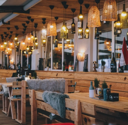 Gemütliche Lounge mit Holztischen und warmenhängenden Lichtern