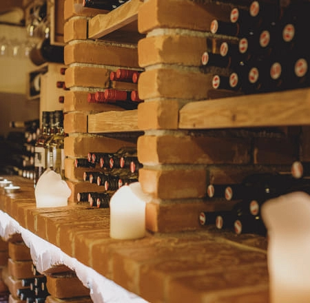 Weinregal mit Flaschen und Kerzen in der Weinlounge