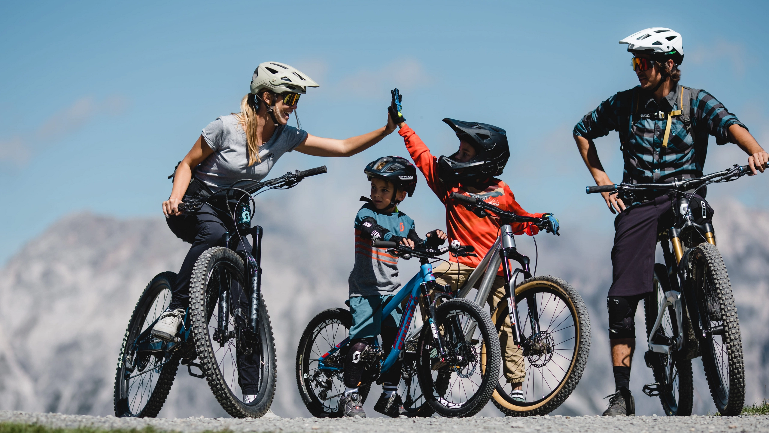 Familie beim Fahrradfahren in den Bergen, hohe Berge im Hintergrund